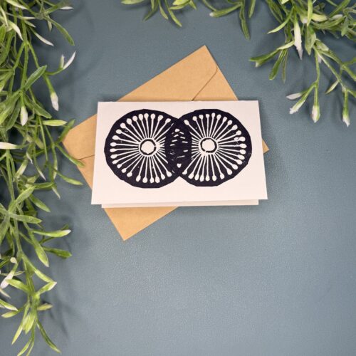 A mini card with a black two wheel design on a green background with a plant