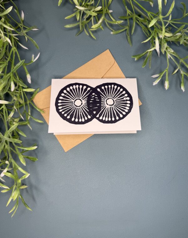 2 Wheels A mini card with a black two wheel design on a green background with a plant