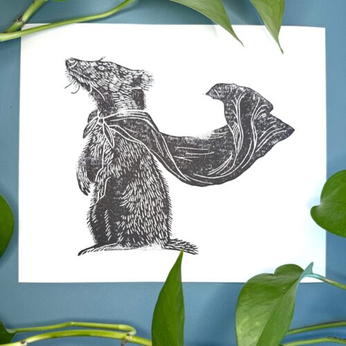 A black ink Badger print on white paper on a green background with a plant
