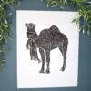 Camel plant A black ink Camel print on white paper on a green background with a plant