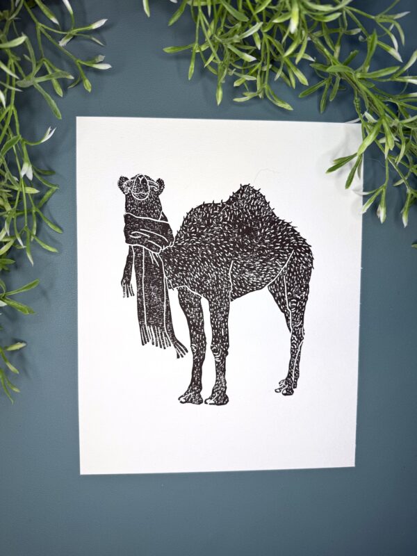 Camel plant A black ink Camel print on white paper on a green background with a plant