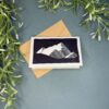 Mountain A mini card with a black and white mountain design on a green background with a plant